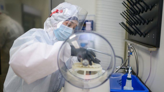 A researcher puts ancient poop into a centrifuge