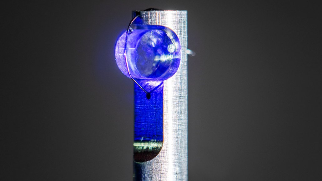 A translucent blue cylindrical crystal mounted on a post