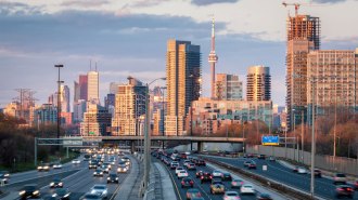 The skies above a city is clear, even as highway traffic seen in the foreground is likely sending some pollutants into the air.