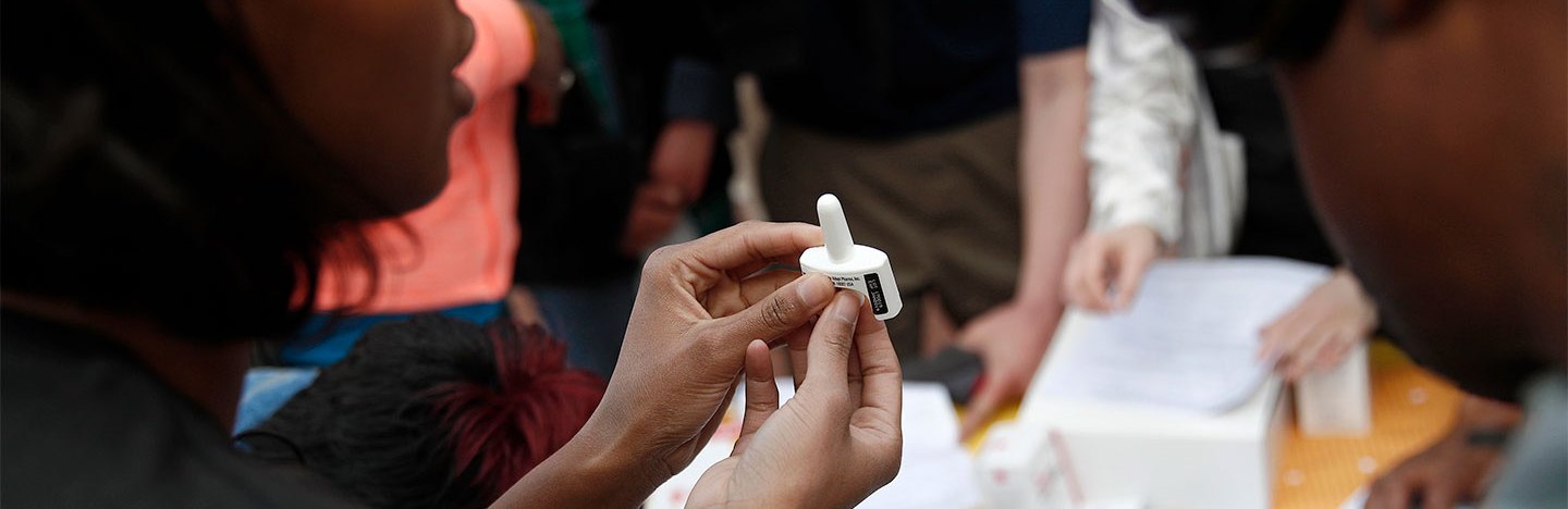 A health worker demonstrates how to use the opioid antidote naloxone nasal spray