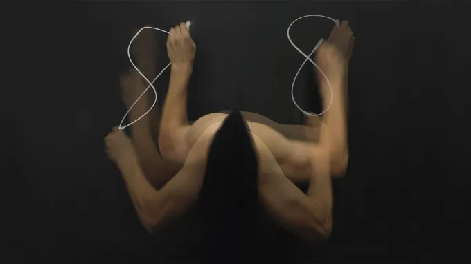 A composite image of arms shows a person writing the number eight with the left hand and the right hand. The eight on the right is smoother.