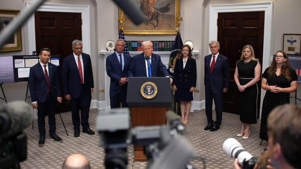 President Trump stands at a lectern, flanked by government officials, during a 2025 briefing on autism.