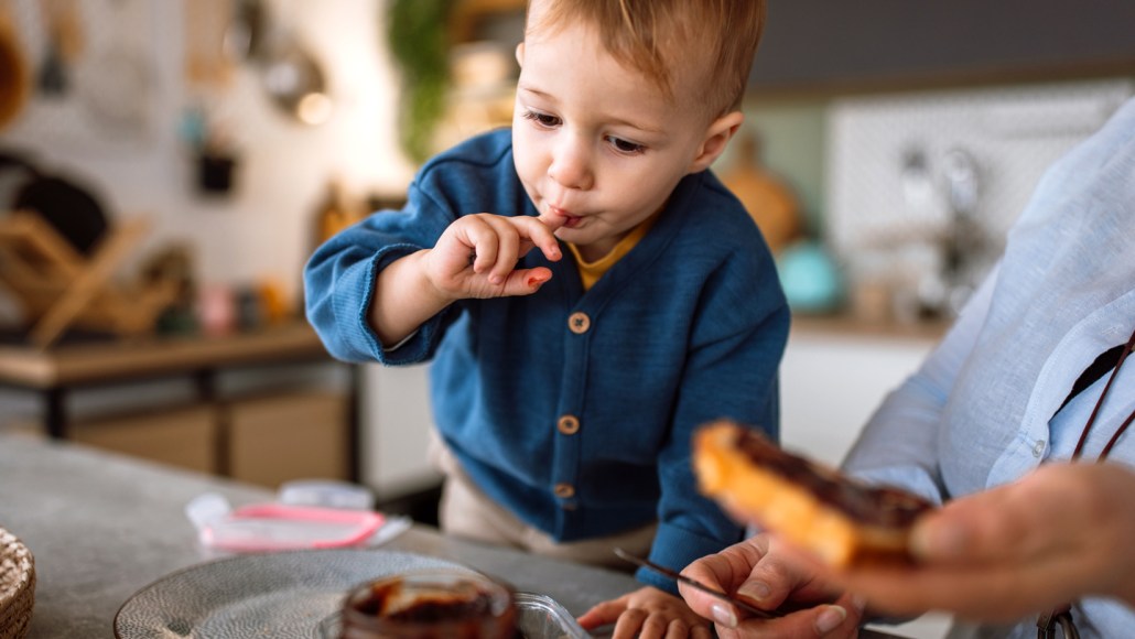 A child dips his finger is sugar
