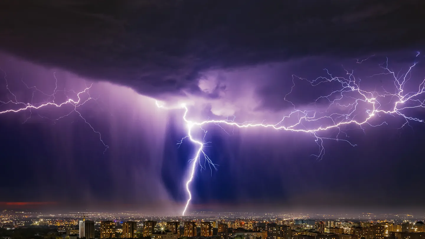 Fiber-optic cable buried underground with a thunderstorm in the background.