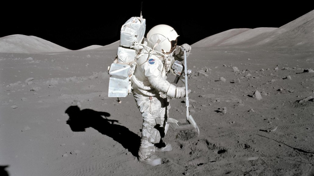 A photo of an astronaut in a space suit collecting a regolith sample on the moon's surface.