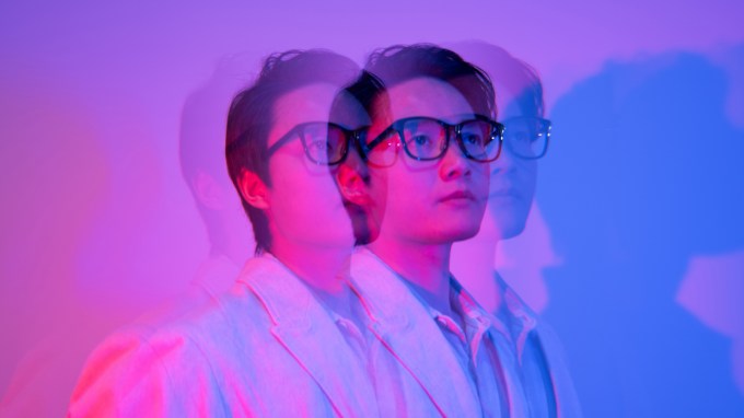 This image shows a person in glasses with superimposed slightly ghosted versions of them to imply the idea of digital twins.